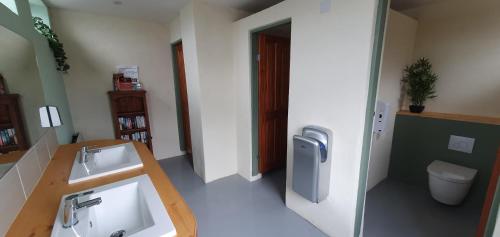 a bathroom with two sinks and a toilet at Marshland Alpacas Glamping Lodge in New Holland