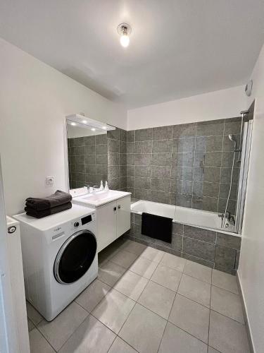 une salle de bain avec une machine à laver et un lavabo dans l'établissement Newwilliam, à Serris