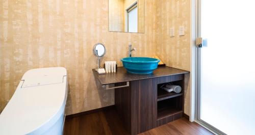 a bathroom with a blue sink and a mirror at HOTEL SANSUI NAHA Ryukyu Onsen Naminoue-No-Yu in Naha
