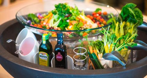 a bowl of salad and two bottles of wine at HOTEL SANSUI NAHA Ryukyu Onsen Naminoue-No-Yu in Naha