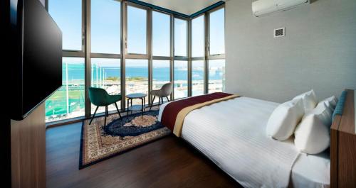 a bedroom with a bed and a view of the ocean at HOTEL SANSUI NAHA　Ryukyu Hot Spring Naminoueyu in Naha
