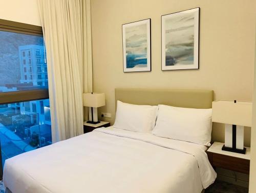 Un dormitorio con una gran cama blanca y una ventana en luxury sea view Address Hotel apartment Fujairah en Fujairah