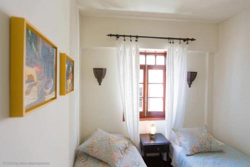 een slaapkamer met 2 bedden en een raam bij Casa Amendoeira - Fabulous Restored Townhouse in Lagos Old Town With Panoramic Roof Terrace in Lagos