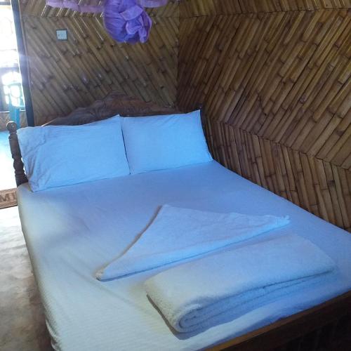 a bed with white towels and pillows on it at Scoop Cabana Kitesurfing in Kalpitiya