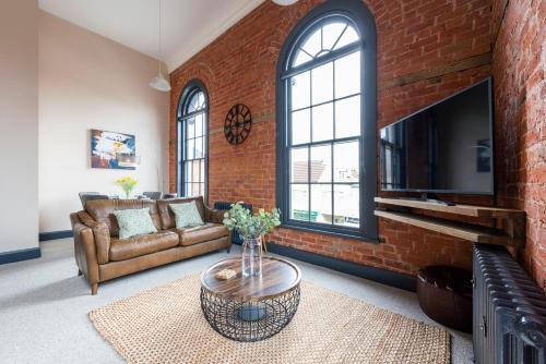 a living room with a brick wall at The Old Chapel Apartments in Edwinstowe