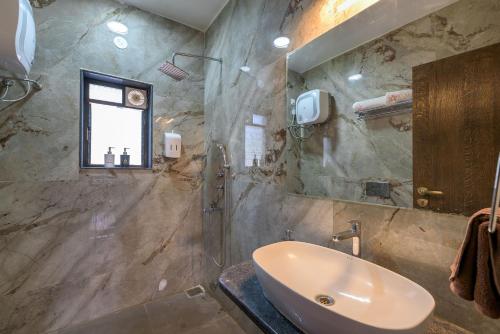 a bathroom with a sink and a shower at SaffronStays Eden, Nashik - pet-friendly villa with pool, jacuzzi & grape farm in Nashik