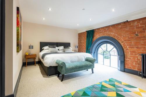 Un dormitorio con una cama y una pared de ladrillo. en The Old Chapel Apartments, en Edwinstowe