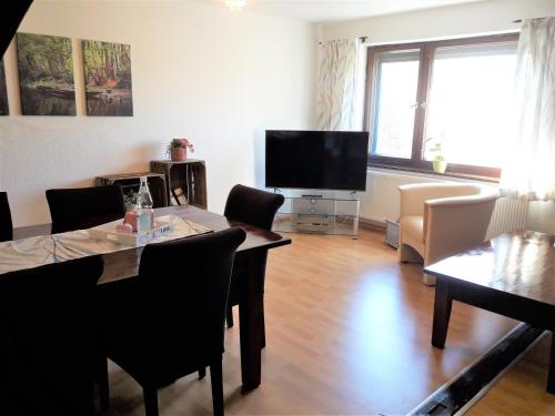 a living room with a table and a flat screen tv at Storchennest Spreewald in Vetschau