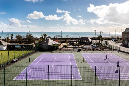 two people playing tennis on a tennis court at Seascape in Penzance