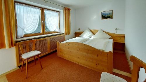 ein Schlafzimmer mit einem Holzbett und einem Fenster in der Unterkunft Ferienwohnung Nr 3, Lechbruck-Gründl, Allgäu in Prem