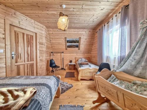 a bedroom with two beds in a log cabin at Domki w Zębie in Ząb