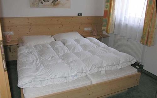 Ferienwohnung Nr 18, Golf- und Ski-Residenz, Oberstaufen-Steibis, Allgäu في اوبرستوفن: سرير عليه شراشف بيضاء في الغرفة