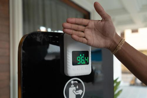 a person holding their hand up to an alarm clock at The Madras Grand in Chennai