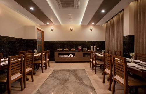 a restaurant with wooden tables and chairs and a counter at The Madras Grand in Chennai