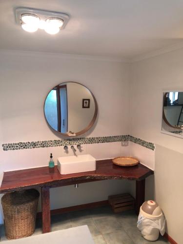 a bathroom with a sink and a mirror at Beautiful, Cosy and Quiet in Cape Paterson