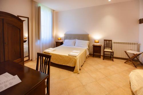 a bedroom with a bed and two chairs and a table at Il Carmine Dimora Storica in Erice