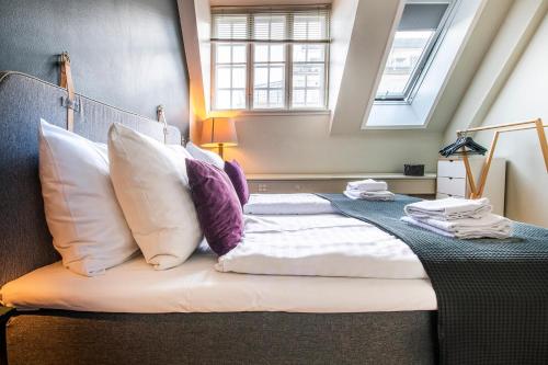 a bedroom with a large bed with pillows at Kings Garden 2 by Daniel&Jacob's in Copenhagen