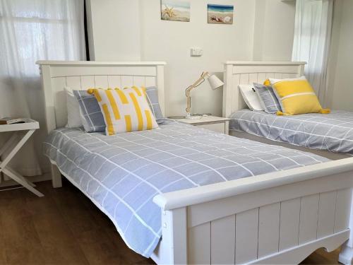 a bedroom with two beds and a lamp at Sealark in Callala Bay