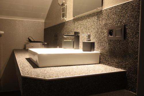 y baño con lavabo blanco y espejo. en B&B Au coin des sources en Sart-lez-Spa