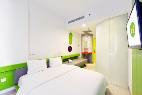 A bed or beds in a room at POP! Hotel Stasiun Kota Surabaya