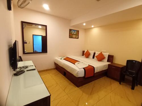 a hotel room with a bed and a mirror at Majestic Inn in Trivandrum