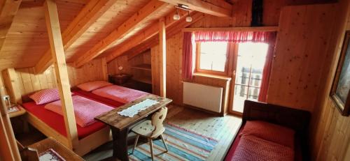 einen Blick über ein Schlafzimmer in einem Blockhaus in der Unterkunft Almgasthaus Flecknerhütte in St. Leonhard in Passeier