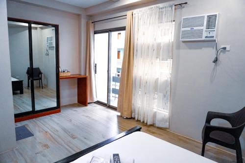 a living room with a table and a room with a window at The Mang-Yan Grand Hotel powered by Cocotel in Puerto Galera