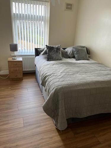 a bedroom with a bed and a window at Milnrow Road - Spacious 3 bed house 