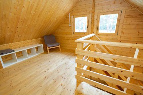 a log cabin with a chair in the attic at Domki Wiosełko in Cieksyn