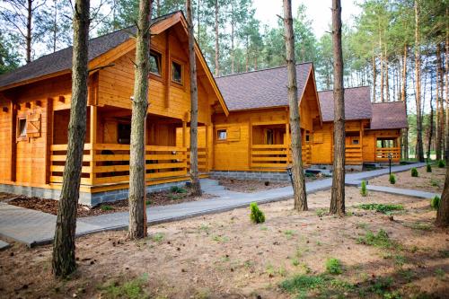 a log cabin in the woods with trees at Domki Wiosełko in Cieksyn