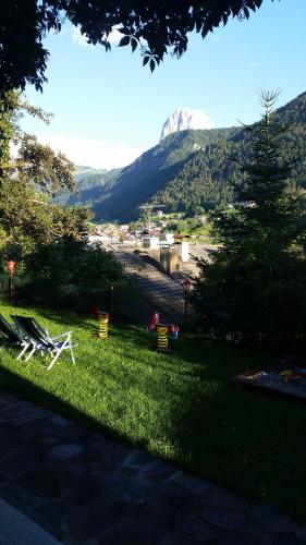a group of lawn chairs sitting in the grass at Hotel Villa Emilia in Ortisei