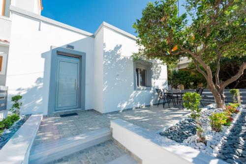 a white house with a blue door at Dias Luxury Homes in Koskinou