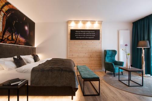 a hotel room with a bed and a chair at Landhaus Grum in Hattingen