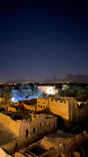 a view of the ruins of a building at night at Alqalah Inn in Al Ḩamrāʼ