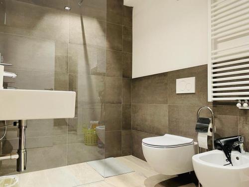 a bathroom with a white toilet and a sink at MUROS - Design Apartments in Trento in Trento