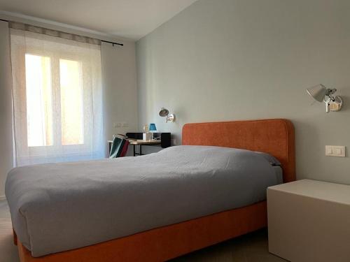 a bedroom with an orange bed and a window at MUROS - City Modern Living in Trento in Trento