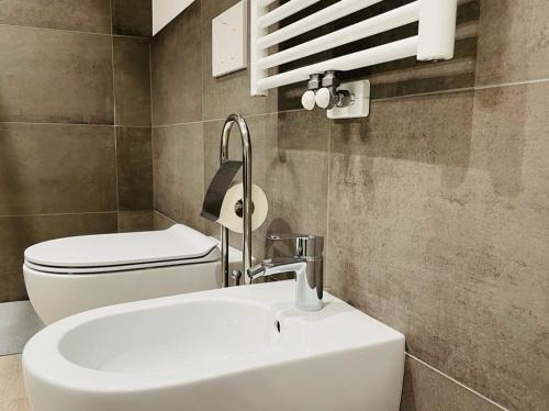 a bathroom with a white sink and a toilet at MUROS - City Modern Living in Trento in Trento