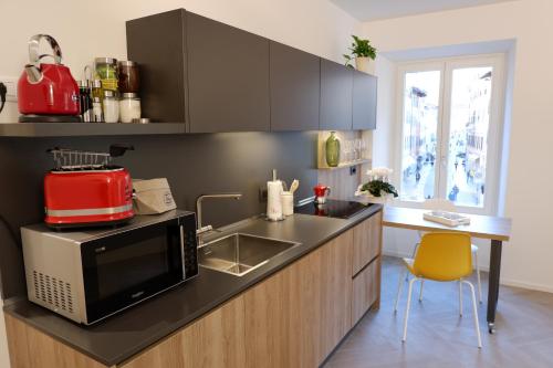 a kitchen with a sink and a microwave at MUROS - City Modern Living in Trento in Trento