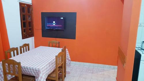a dining room with a table and a television on a wall at Alojamiento Familiar Nobili in Puerto Iguazú