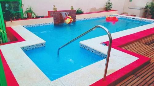 a pool with a water slide in the middle at Alojamiento Familiar Nobili in Puerto Iguazú