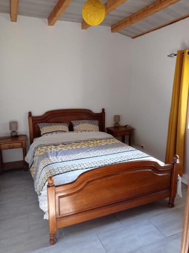 a bedroom with a wooden bed in a room at La Cave in Auzon