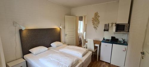 1 dormitorio con 1 cama blanca y 2 almohadas en SJÖTORPS HOSTEL, en Sjötorp