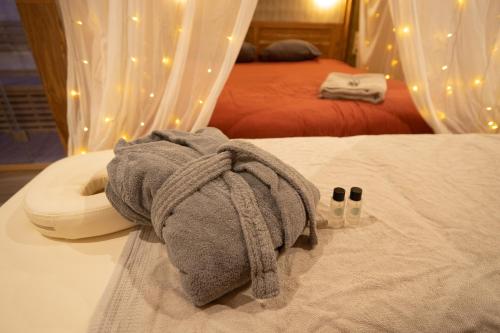 a pile of towels sitting on top of a bed at Capsule Marrakech I Chicha I Sauna I Balnéo I Console PS5 I Cinéma in Trith-Saint-Léger