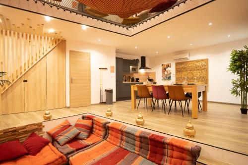 ein Wohnzimmer mit einem Sofa und einem Tisch in der Unterkunft Capsule Marrakech I Chicha I Sauna I Balnéo I Console PS5 I Cinéma in Trith-Saint-Léger