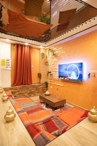 a large room with a table and a large screen at Capsule Marrakech I Chicha I Sauna I Balnéo I Console PS5 I Cinéma in Trith-Saint-Léger
