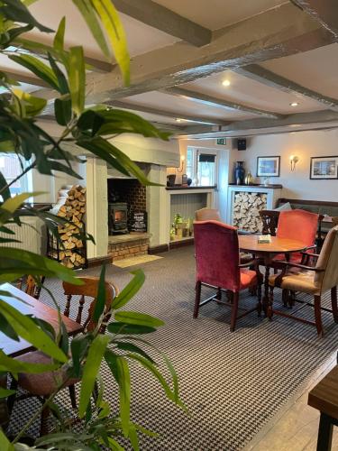 a living room with a table and chairs at Tollemache Arms in Calveley