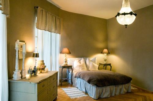 een slaapkamer met een bed, een dressoir en een kroonluchter bij Schloss Amerang in Amerang