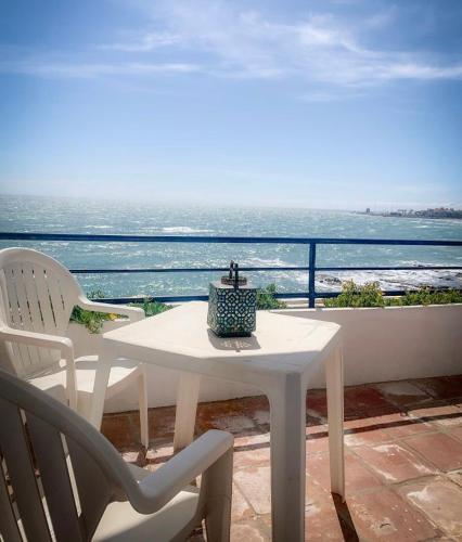 a table and chairs on a balcony with the ocean at Hotel Patricia in Torreguadiaro