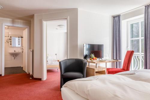 a hotel room with a bed and a desk and chair at Apartmenthotel Weilburg in Weilburg