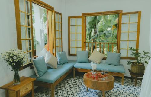 a living room with blue couches and a table at The Wooden Gate in Xuân Sơn